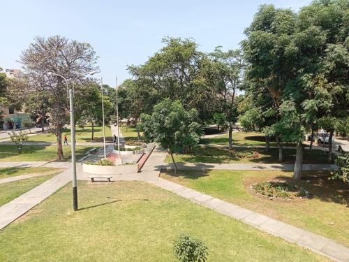 a park with a bench in the grass at ROARI HOTEL in Trujillo