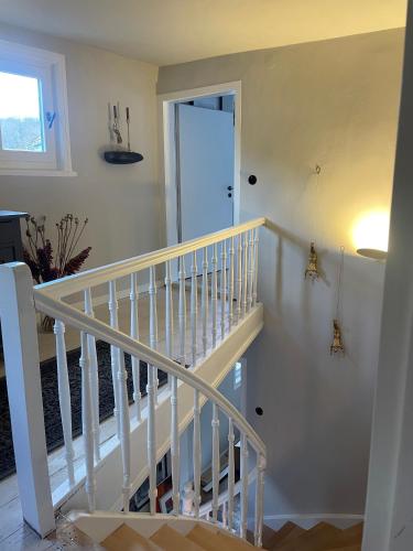 a white staircase in a house with a door at Rosehill Cottage 1699 - Stilvolles Hideaway, Berge & See in Eisemroth