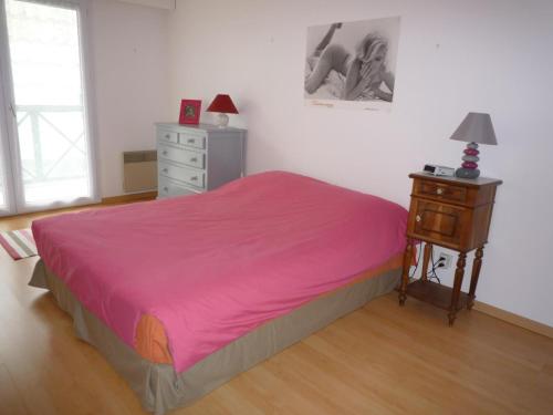um quarto com uma cama rosa com uma cómoda e uma mesa de cabeceira em Appartement Les Sables-d'Olonne, 2 pièces, 4 personnes - FR-1-92-699 em Les Sables-dʼOlonne