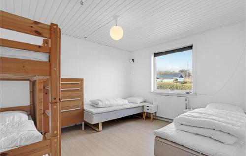 a bedroom with two bunk beds and a window at Awesome Home In Allinge With 5 Bedrooms And Wifi in Allinge