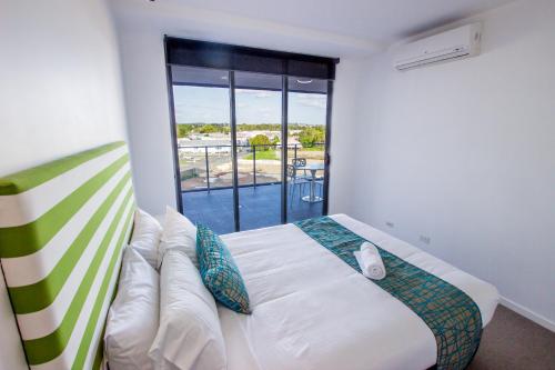 a bedroom with a bed and a large window at Eastwood Apartments in Brisbane