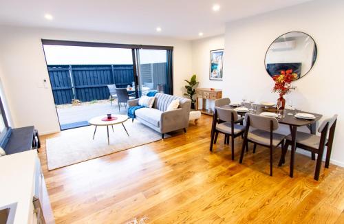 a living room with a table and a dining room at 2 bed paradise near Hagley Park in Christchurch
