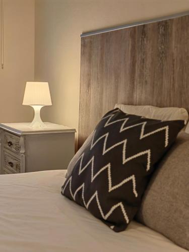 a bed with a black and white pillow and a lamp at Vale Da Misarela in Geres
