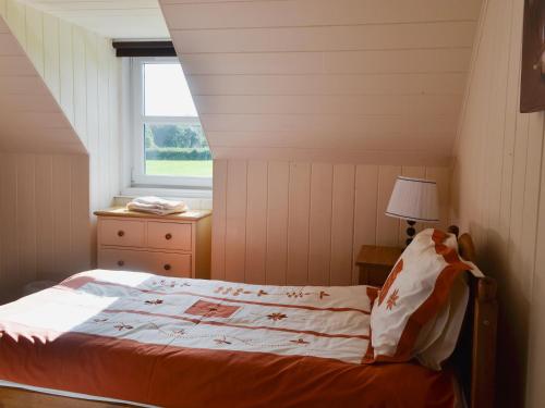 a bedroom with a bed and a window at Rose Cottage - Beaufort Estate in Belladrum