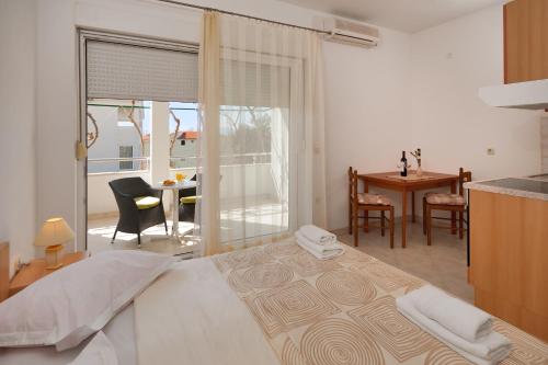 a bedroom with a bed and a table with chairs at House Marta in Baška Voda