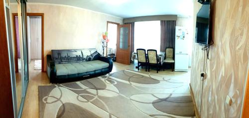 uma sala de estar com um sofá e uma sala de jantar em 3х комнатная квартира центр Костанай em Amangelʼdy