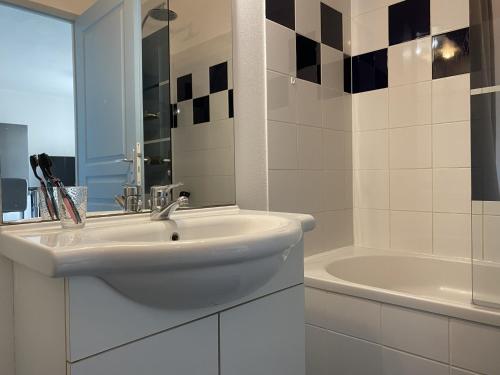 a white bathroom with a sink and a tub at Appartement 2 pièces avec climatisation, parking, proche plage, commerces et activités - Classé 3 étoiles - FR-1-338-426 in Sète