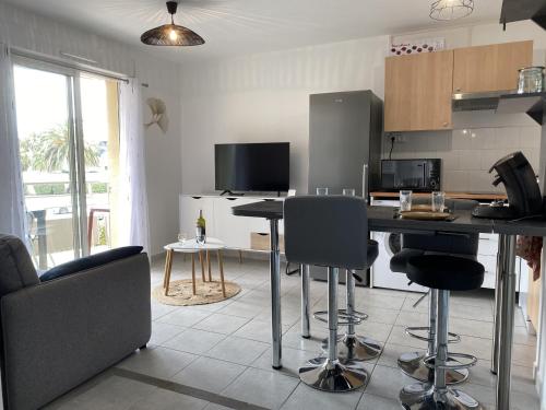 une cuisine avec une table et des chaises dans une pièce dans l'établissement Appartement 2 pièces avec climatisation, parking, proche plage, commerces et activités - Classé 3 étoiles - FR-1-338-426, à Sète
