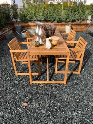 a wooden table with chairs and a vase on it at Rosehill Cottage 1699 - Stilvolles Hideaway, Berge & See in Eisemroth