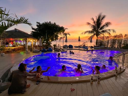 a group of people in a pool with the ocean in the background at Siam Cookies Cottage in Haad Pleayleam