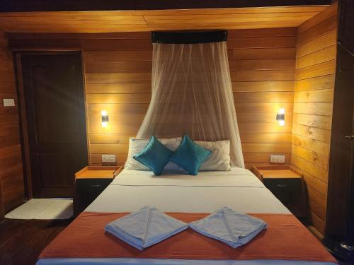 a bedroom with a bed with two pillows on it at Wilpattu Tree House in Wilpattu
