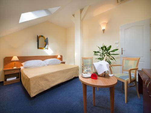 a bedroom with a bed and a table and chairs at EA Hotel Tosca in Prague