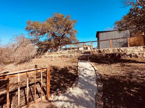 a stairway leading up to a house with a fence at 11th Street River House in Bandera