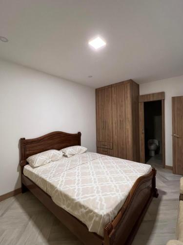 a bedroom with a large bed with a wooden headboard at Apartamento Violeta con Impresionante Vista al Mar in Playas