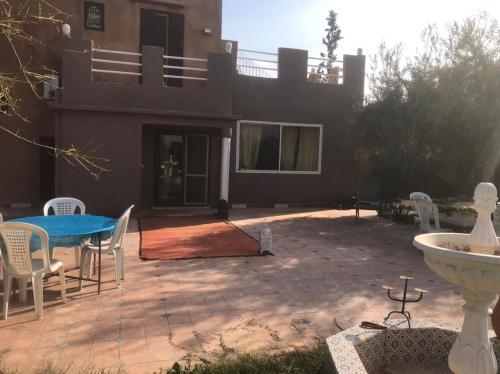 a patio with a table and chairs in front of a house at Walid in Marrakech