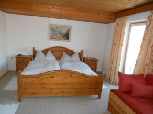 1 dormitorio con cama de madera y almohadas blancas en Haus Edelweiß, en Unterwossen