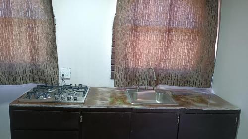 a kitchen with a sink and a stove at Chocolate condo in San Felipe