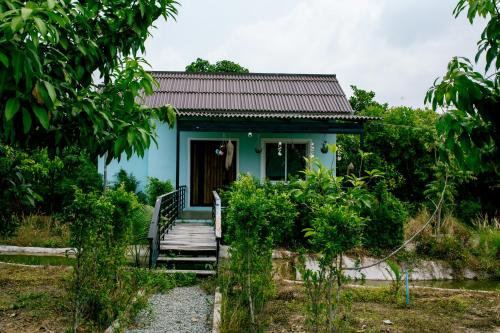 a blue house with a staircase leading to it at HaiVen Farm Homestay in Phumĭ Khŭn Réam