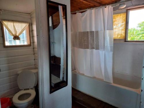 a bathroom with a toilet and a tub and a shower at Elba House in Bocas del Toro