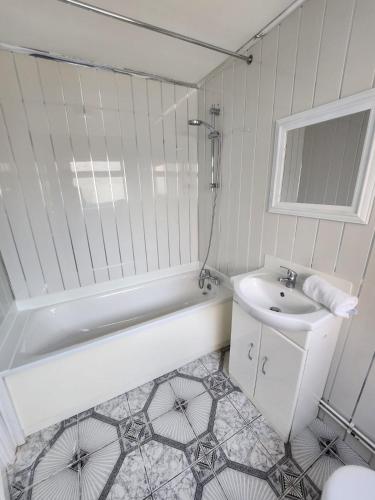 a white bathroom with a sink and a bath tub at Bamville Shared House in Birmingham