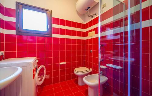 a red tiled bathroom with a toilet and a sink at Trilo 5 in San Teodoro