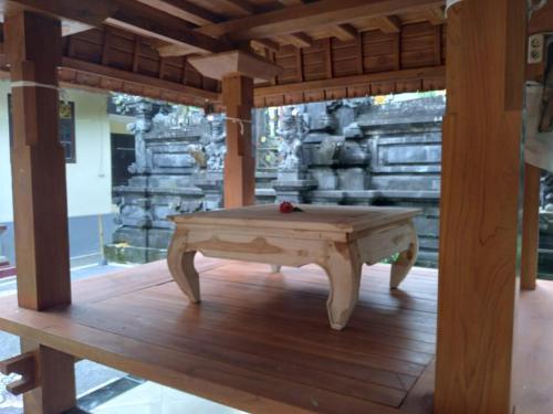 a ping pong table on a wooden floor in a room at Rindu Homestay in Undisan