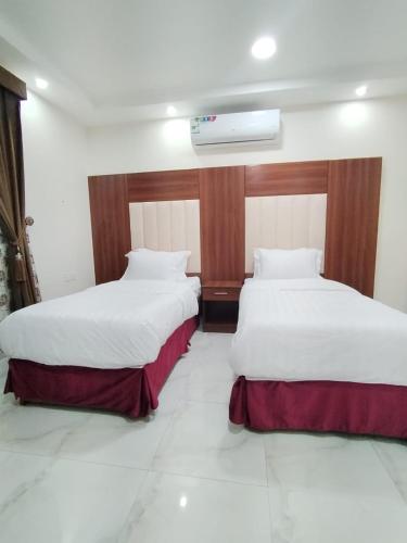 duas camas sentadas uma ao lado da outra num quarto em هوتيل نجران للشقق الفندقية em Najran