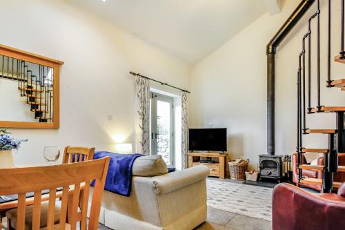 a living room with a couch and a tv at No 4 The Shippon in Llangefni