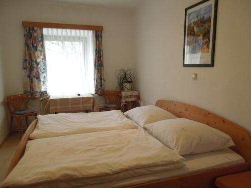 1 dormitorio con 1 cama grande con sábanas blancas en Frühstückspension Kammerer en Kleinpöchlarn