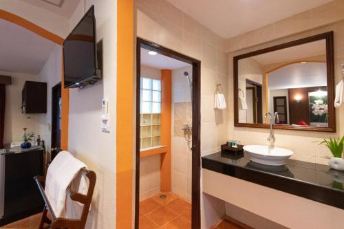 a bathroom with a sink and a mirror at Aochalong Villa Resort & Spa - SHA Plus in Chalong