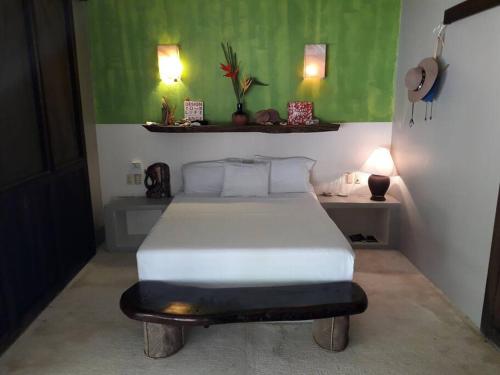 ein Schlafzimmer mit einem weißen Bett in einem Zimmer in der Unterkunft Casa KUUL, elegant fusion of house and garden. in Puerto Escondido