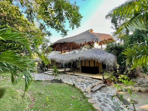 una casa con techo de paja y patio en Casa KUUL, elegant fusion of house and garden. en Puerto Escondido