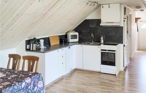 a kitchen with white cabinets and a stove top oven at Beautiful Apartment In Gotlands Tofta in Gnisvärd