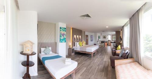 a room with two beds and a living room at Aochalong Villa Resort & Spa - SHA Plus in Chalong
