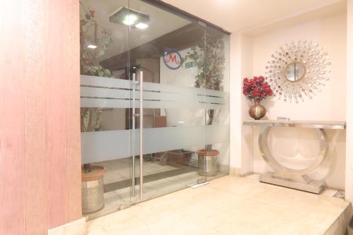 een glazen douche in een badkamer met een toilet bij Hotel Mohan in Lucknow