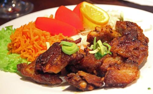 a plate of food with chicken and rice and carrots at Guesthouse Carl Schmidt in Põltsamaa