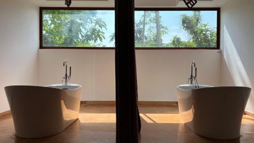 2 aseos en una habitación con ventana en Palm Garden Ayurveda Resort en Ahangama