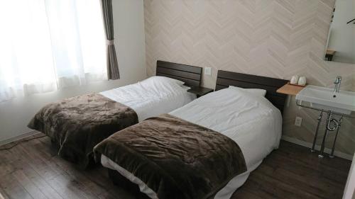 a hotel room with two beds and a sink at Sarabetsu-mura chiiki Kouryu Center - Vacation STAY 21964v in Naka-satsunai