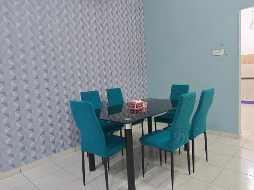 een eetkamer met een tafel en blauwe stoelen bij Happy homestay sitiawan in Sitiawan