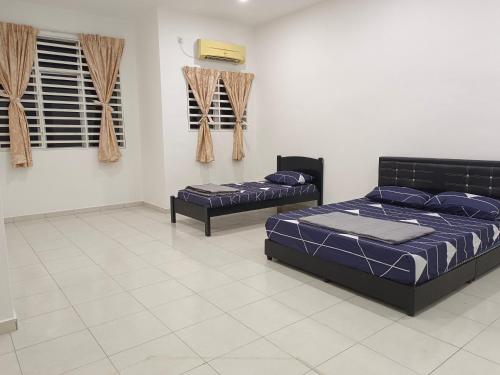 2 bedden in een kamer met een witte tegelvloer bij Happy homestay sitiawan in Sitiawan