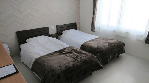 two beds in a small room withskirts at Sarabetsu-mura chiiki Kouryu Center - Vacation STAY 35300v in Naka-satsunai
