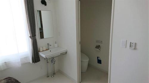 Baño blanco con lavabo y aseo en Sarabetsu-mura chiiki Kouryu Center - Vacation STAY 35300v, en Naka-satsunai