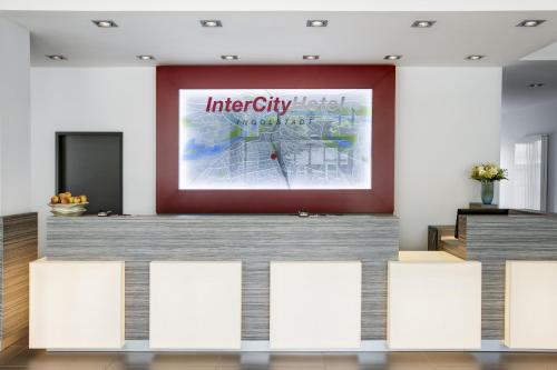 a stage with white chairs in front of a large screen at IntercityHotel Ingolstadt in Ingolstadt
