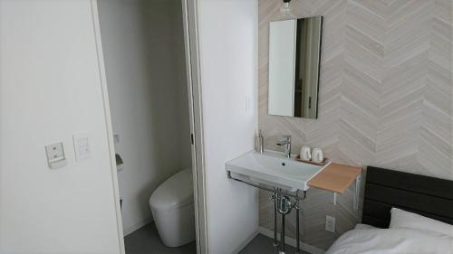 uma casa de banho com um lavatório, um WC e um espelho. em Sarabetsu-mura chiiki Kouryu Center - Vacation STAY 25699v em Sarabetsu