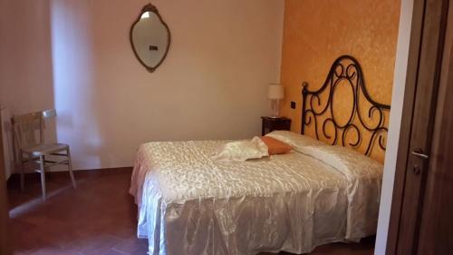 ヴォルテッラにあるAgriturismo Santa Adrianaのベッドルーム1室(ベッド1台、壁掛け鏡付)