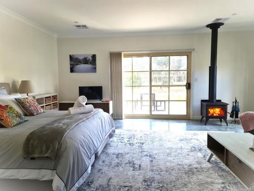 a bedroom with a large bed and a fireplace at Canyonleigh Retreat in Canyonleigh