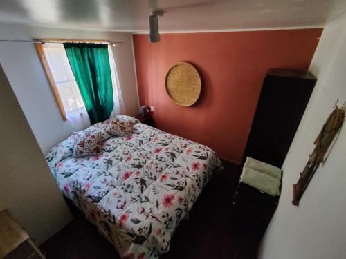 a small bedroom with a bed and a green curtain at CABAÑA SAN PEDRINA in San Pedro de Atacama