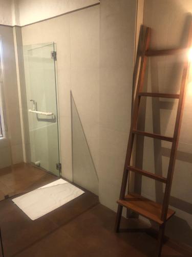 a shower with a glass door and a ladder at Wada1 in Aihole