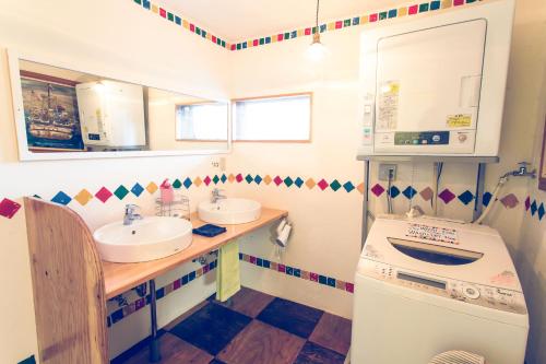 a bathroom with two sinks and a washing machine at Guest House Waya in Sapporo