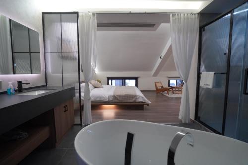 a bathroom with a bath tub and a bedroom at Yi Chen San She in Hangzhou